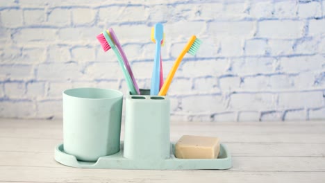 ful toothbrushes in white mug against a wall