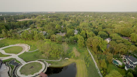 Forward-flyover-beautiful-park-and-pond-and-then-nice-houses-in-upscale-neighborhood-in-Town-and-Country-in-St