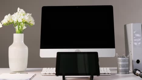 computer, digital tablet and flower vase