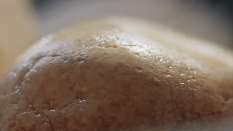 Throwing-water-on-hot-stones-in-the-sauna-stove,-slow-motion-extreme-close-up-of-water-splashing-and-evaporating-into-steam,-heating-the-sauna