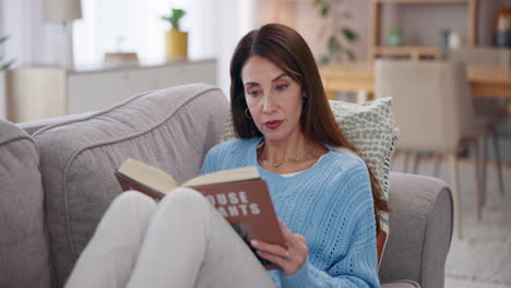 mujer leyendo un libro sobre plantas de la casa en un sofá en una sala de estar