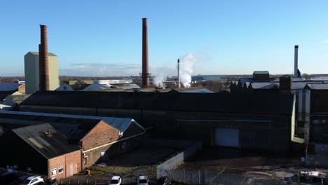 Pilkington-glass-factory-warehouse-buildings-aerial-dolly-view-across-industrial-town-manufacturing-facility