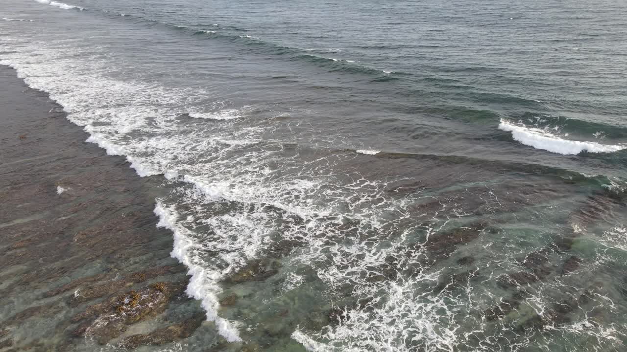 Vista aerea di onde oceaniche che si infrangono su una barriera corallina poco profonda