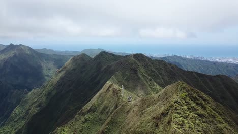 Drone-4000ft-up-in-the-air-in-Oahu-getting-a-shot-of-the-mountain-top-trail-of-the-Stairway-to-Heaven,-panning-up-revealing-the-view