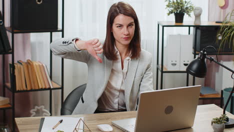 Geschäftsfrau,-Die-Im-Büro-Am-Laptop-Arbeitet-Und-Daumen-Nach-Unten-Zeigt,-Zeichen-Geste-Der-Abneigung-Und-Missbilligung