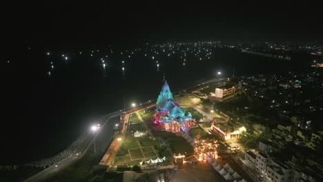 aerial view of illuminated temple at night by the sea