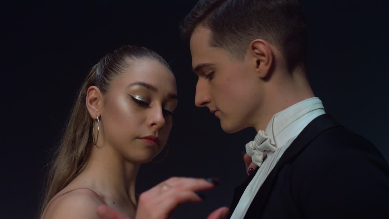 댄스실 커플이 실내에서 춤을 추기 위해 준비하고 있습니다. 젊은 댄서들이 손을 잡고 있습니다.