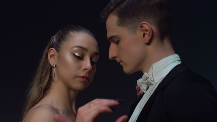 Ballroom couple preparing to start dance indoors. Young dancers holding hands.