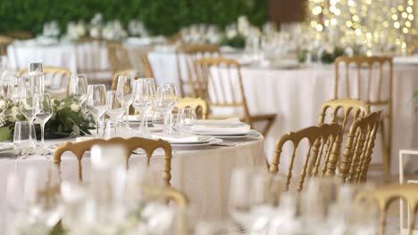 luxurious wedding table setting with golden chairs, glassware, and floral centerpieces
