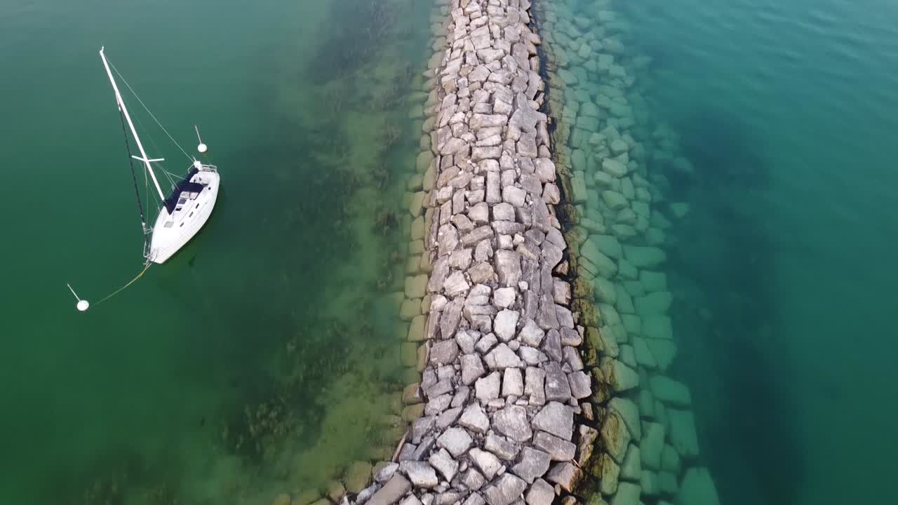 Barca bianca che galleggia e all'ancora vicino al porto sul Lago Michigan a Leland, Michigan, USA.