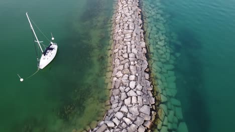 White-Boat-Floating-And-Anchored-Near-The-Harbor-By-The-Lake-Michigan-In-Leland,-Michigan,-USA