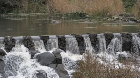 Flusswasser-Strömt-über-Steinwehr,-Zeitlupe