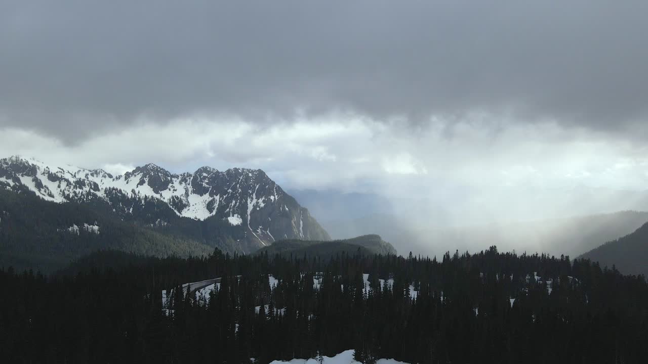 Aerial drone shot flying over the snowy mountains of Mount Rainier during winter, showcasing a vast white landscape