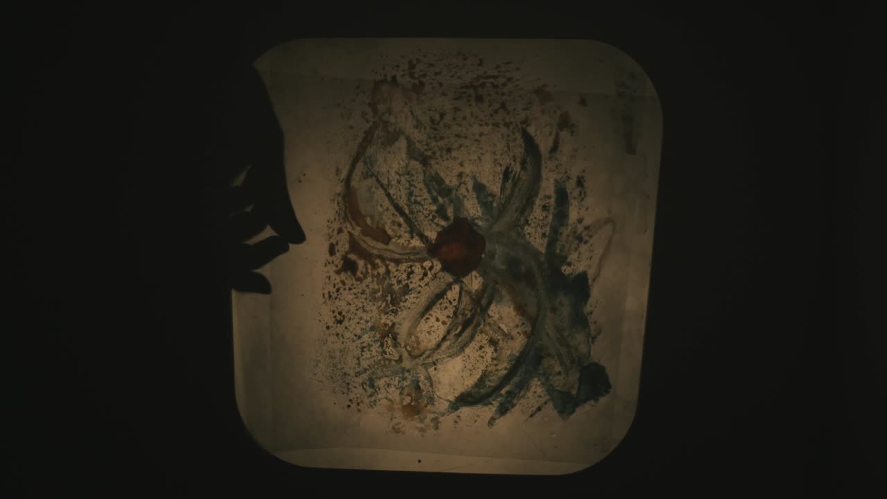 artista creando una obra maestra con pinturas y acetatos, combinando con la interacción de la luz