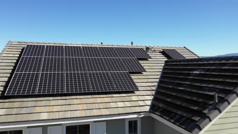 Fast-forward,-solar-panels-on-roof-of-modern-home,-Tustin-aerial