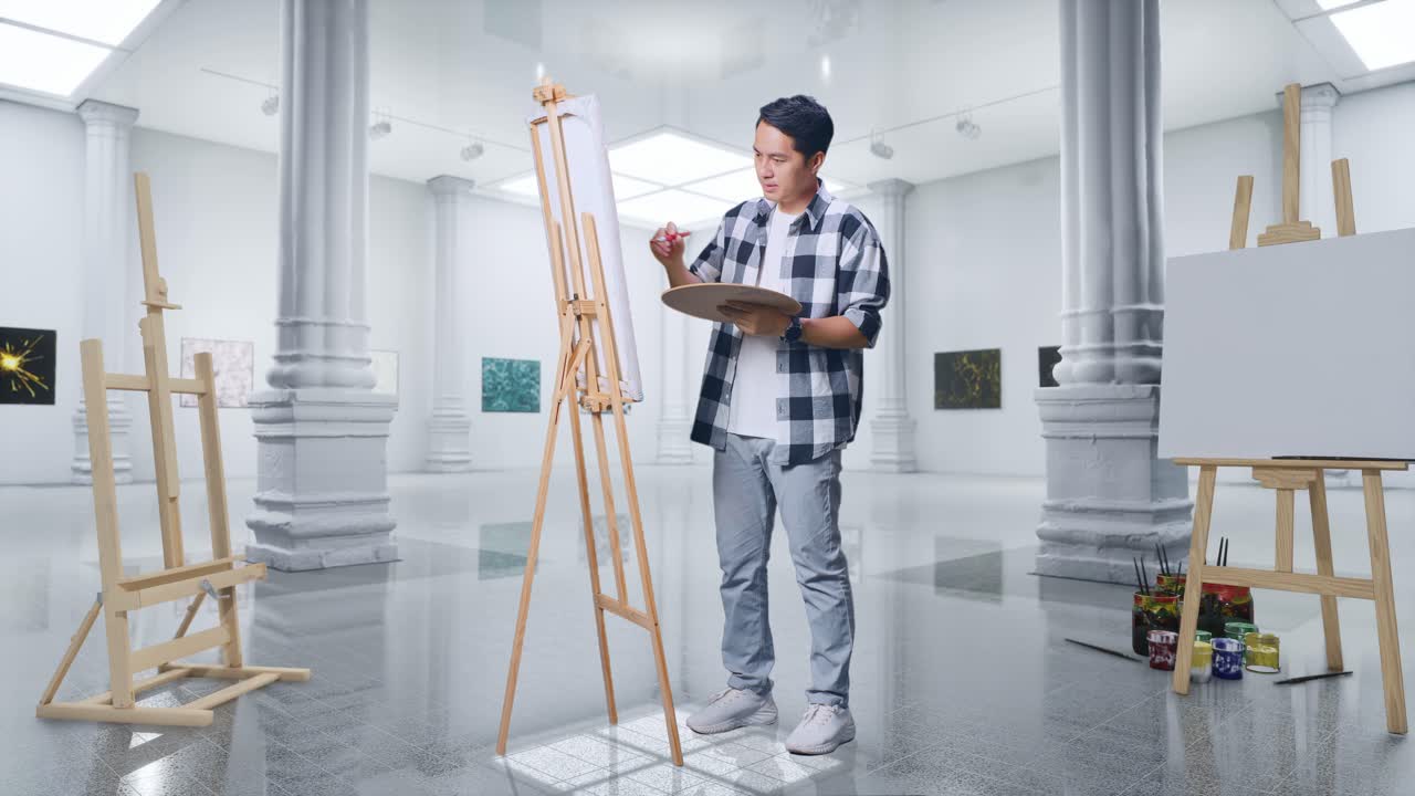 갤러리에서 오일 페인트와 으로 캔버스에 그림을 그리는 동안 미소 짓고 카메라에 평화의 몸짓을 보여주는 아시아 남성 예술가의 몸이 가득 차 있습니다.