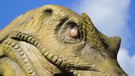 scary giant beast from history looking for his prey angry face irritating massive teeth with a big mouth realistic model details carved wood zoo safari playground vibrant colours slow motion