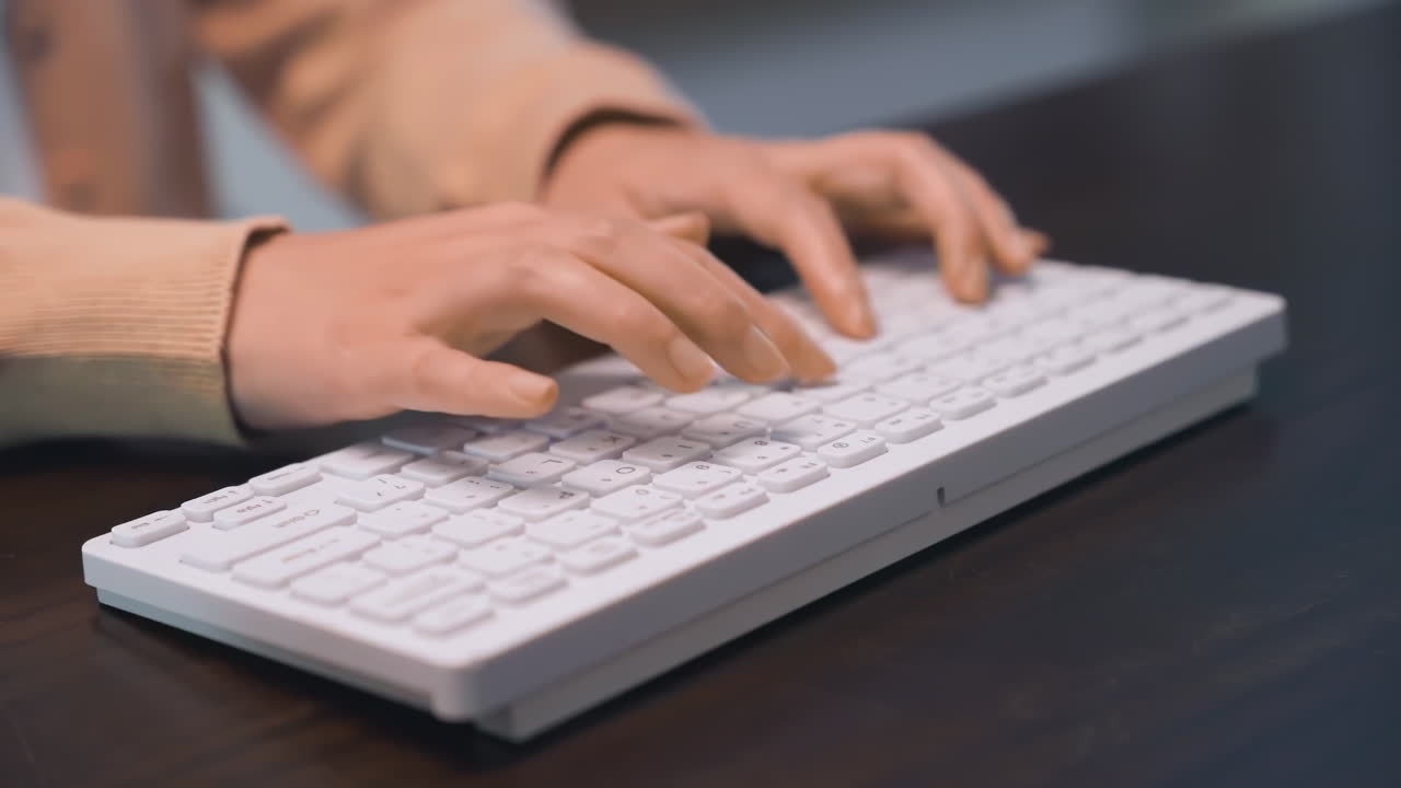 オフィスで深夜、デスクでキーボードを打つ女性の手。デジタルワーク、コーディング、データ入力、カスタマーサービス、テクノロジー、サイバーセキュリティ、夜勤のイメージ。