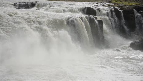 Majestuosa-Toma-Panorámica-De-Una-Serie-De-Enormes-Cascadas-Que-Caen-En-Cascada-Hacia-Un-Río-Blanco-Y-Espumoso