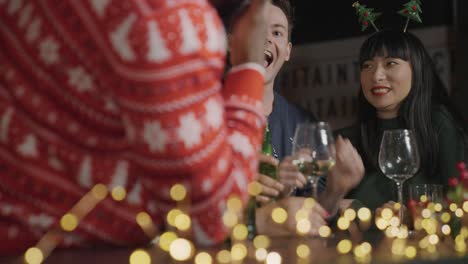 Low-Angle-Shot-of-Drunk-Man-with-His-Friends-During-Christmas-Celebrations-at-a-Bar