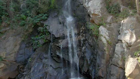 waterfall flowing through crag mountains - cascada de yelapa in jalisco, mexico