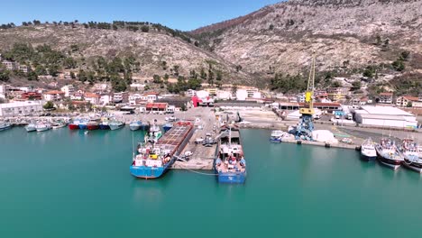 aerial dolly over dock and shipyard with large marine transport vessel