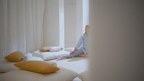 dreamy woman relaxing alone in cozy yoga space. peaceful manager rest after work