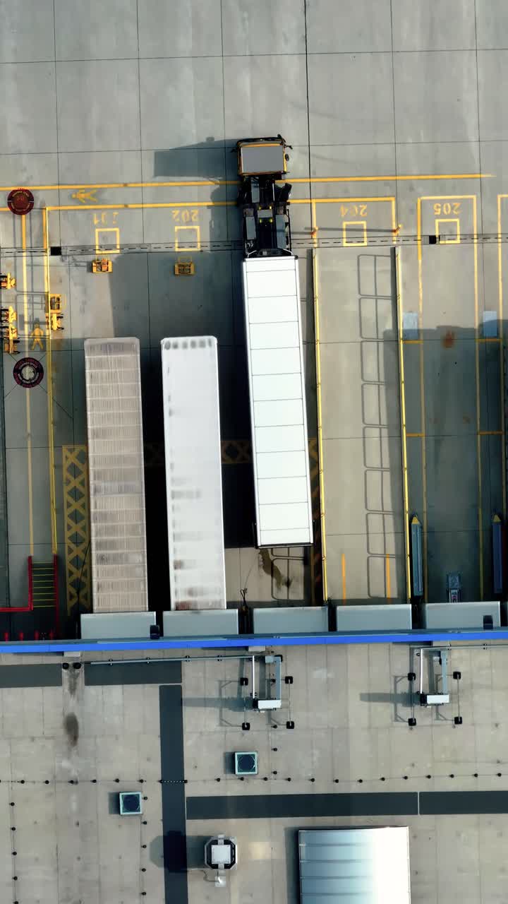 Aerial view of loading dock with trucks and freight containers. Vertical video