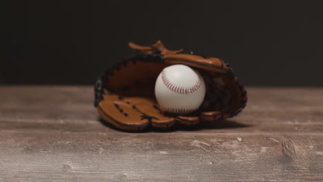 Close-Up-Studio-Baseball-Still-Life-With-Ball-In-Catchers-Mitt-On-Wooden-Floor