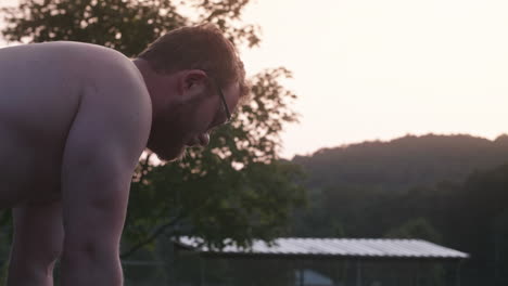 man contemplating during exercise in between sets, medium shot, slow motion