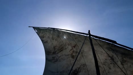 Close-up-of-the-old-sail-of-a-rustic-boat-on-the-island-of-Zanzibar-as-the-sun's-rays-penetrate-from-behind