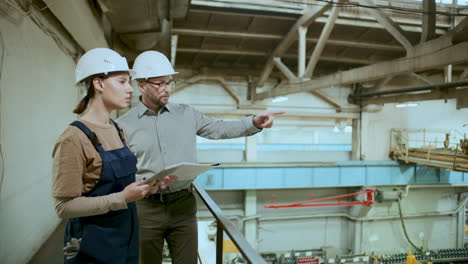 engineer and technician overseeing and discussing factory equipment