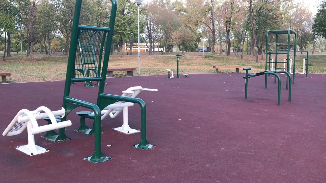 primer plano de un gimnasio al aire libre abierto las 24 horas con dos ciclistas en segundo plano.