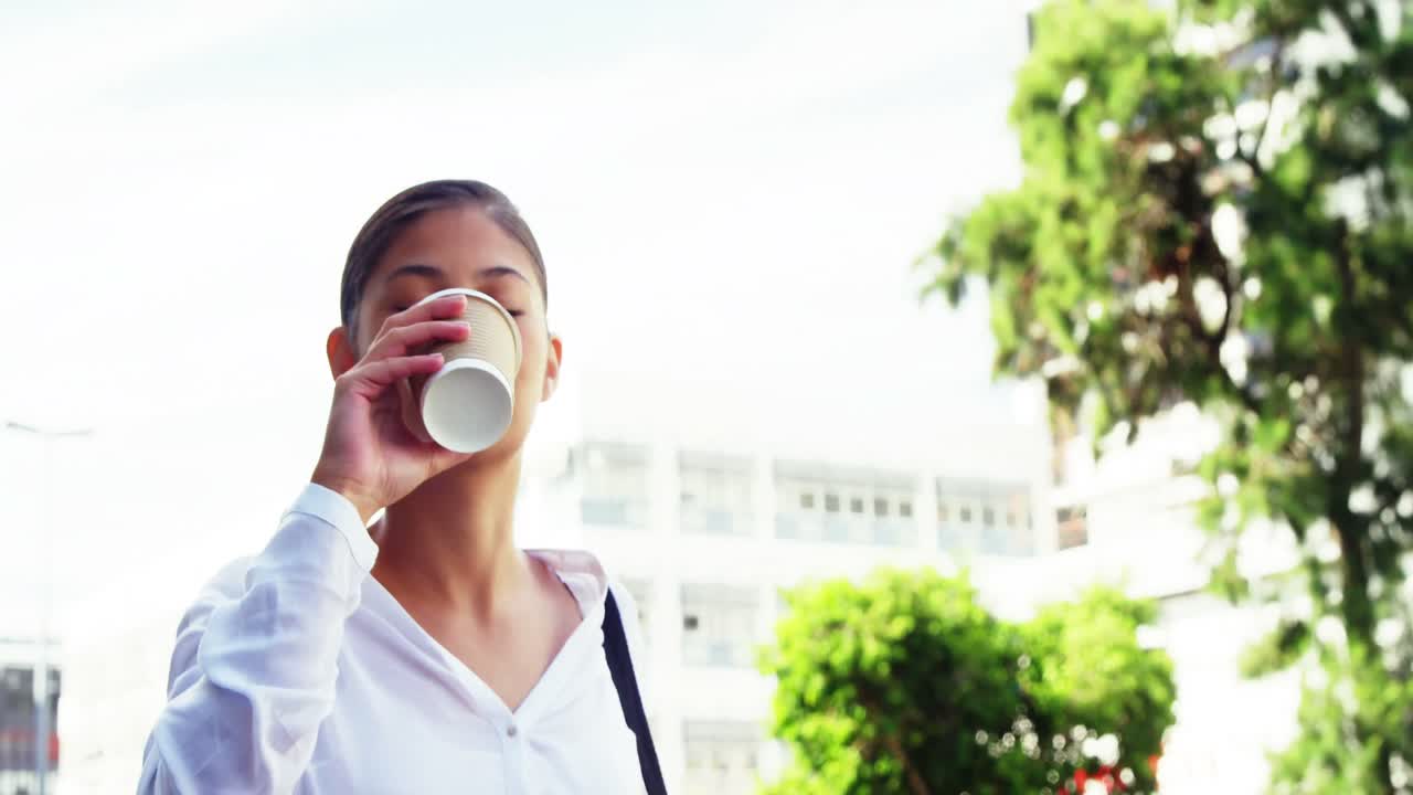 거리에서 커피를 마시는 여자