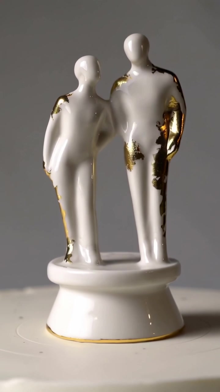Vídeo vertical: Câmera giratória revelando casal de cerâmica esmaltada em pedestal para exibir fichas de ouro.