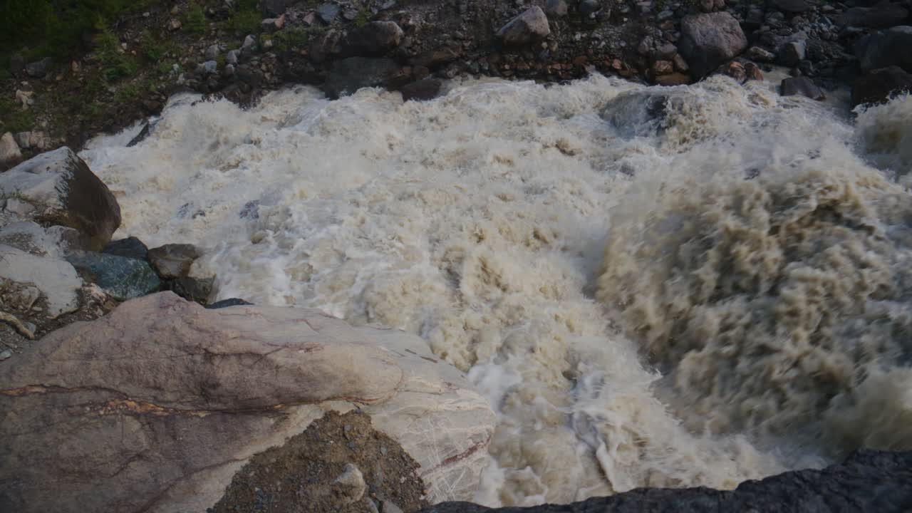 Acqua Impetuosa del Fiume si Infrange sulle Rocce. Il Flusso Turbolento Crea Schiuma Bianca e Spruzzi. La Scena Mostra la Potenza della Natura e la Bellezza Selvaggia. Ideale per Documentari sulla Natura o Contenuti di Avventura