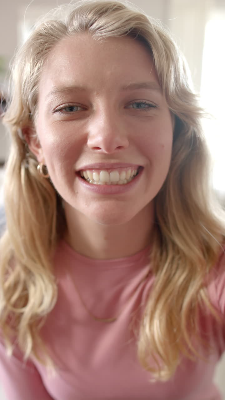 Vertical video of portrait of caucasian woman talking and having video call at home, slow motion