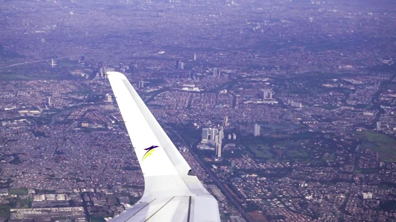 비행기 날개 위로 자카르타 시를 공중 비행하다