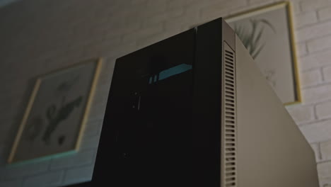 person pushing a power button on a computer case at night