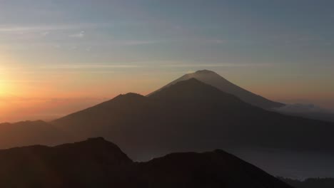 spectacular mountain landscape with landmark volcanos in bali during sunrise, aerial