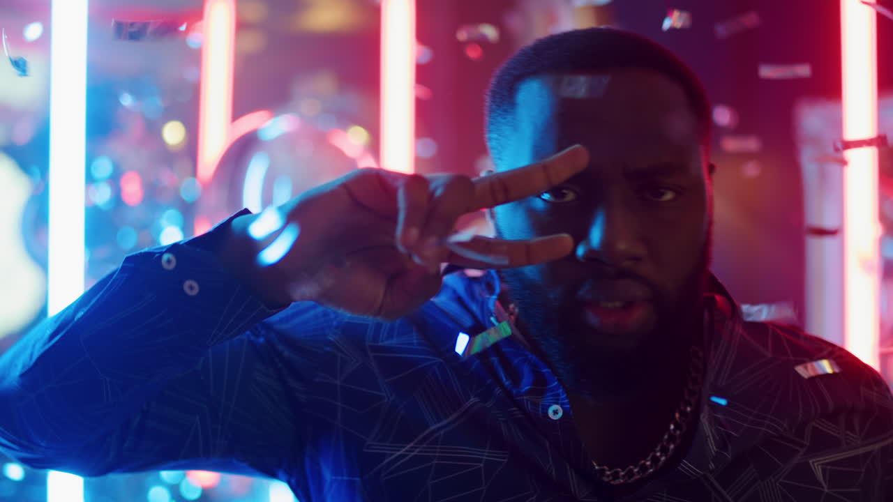 hombre afro guapo disfrutando de la discoteca en la fiesta. hombre moviendo el cuerpo y la mano en el club