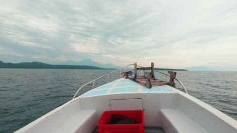 a point-of-view boat ride approaching menjangan island, located off the northwest coast of bali, indonesia. the crystal-clear water, distant tropical shoreline, and serene motion