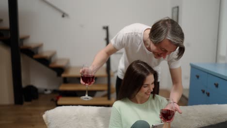 hombre guapo trayendo vasos de vino a su esposa en cámara lenta