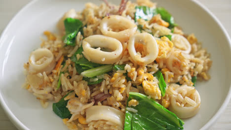 fried rice with squid or octopus in bowl - stir-fried rice with squid, egg and kale