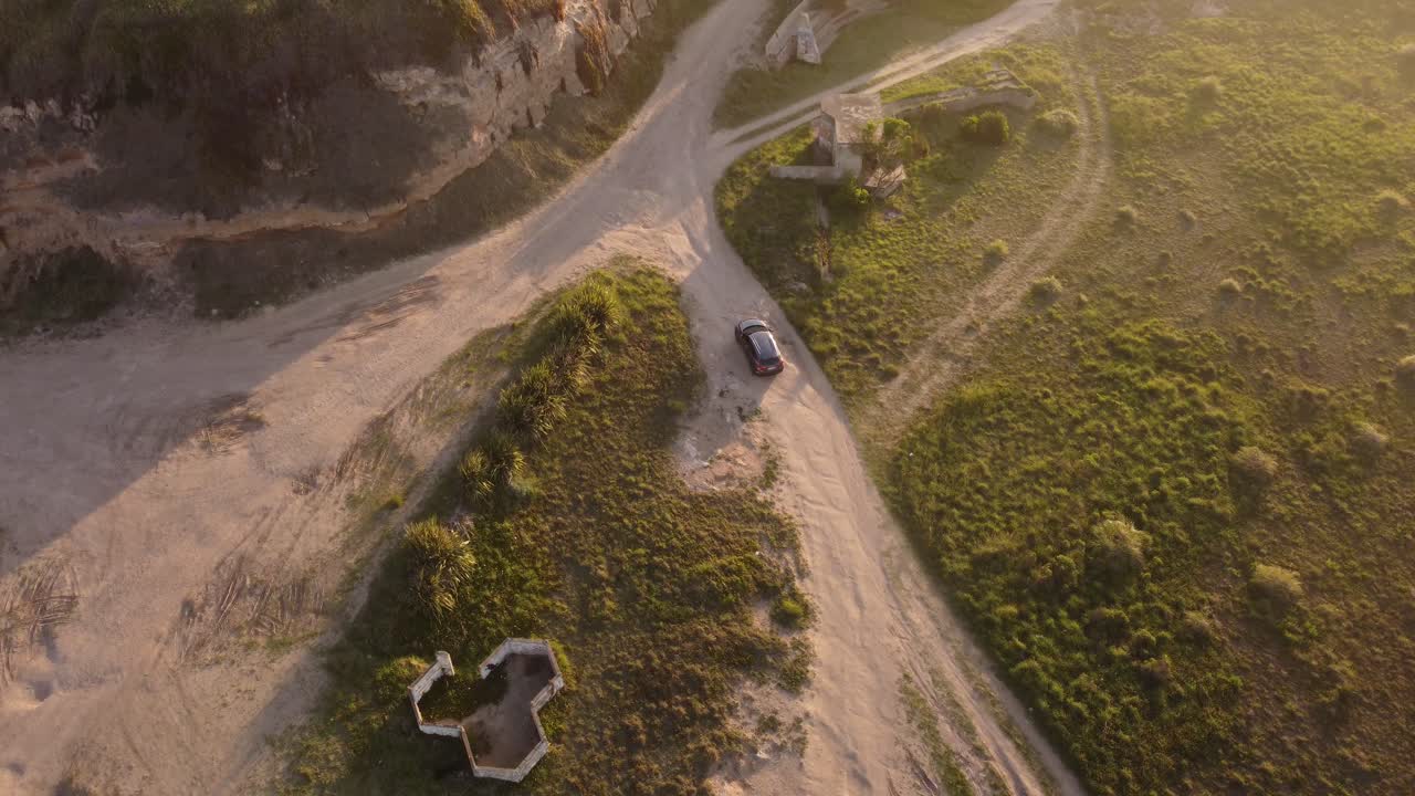 vehículo rojo aislado conduciendo por carretera sin pavimentar, chapadmalal en argentina