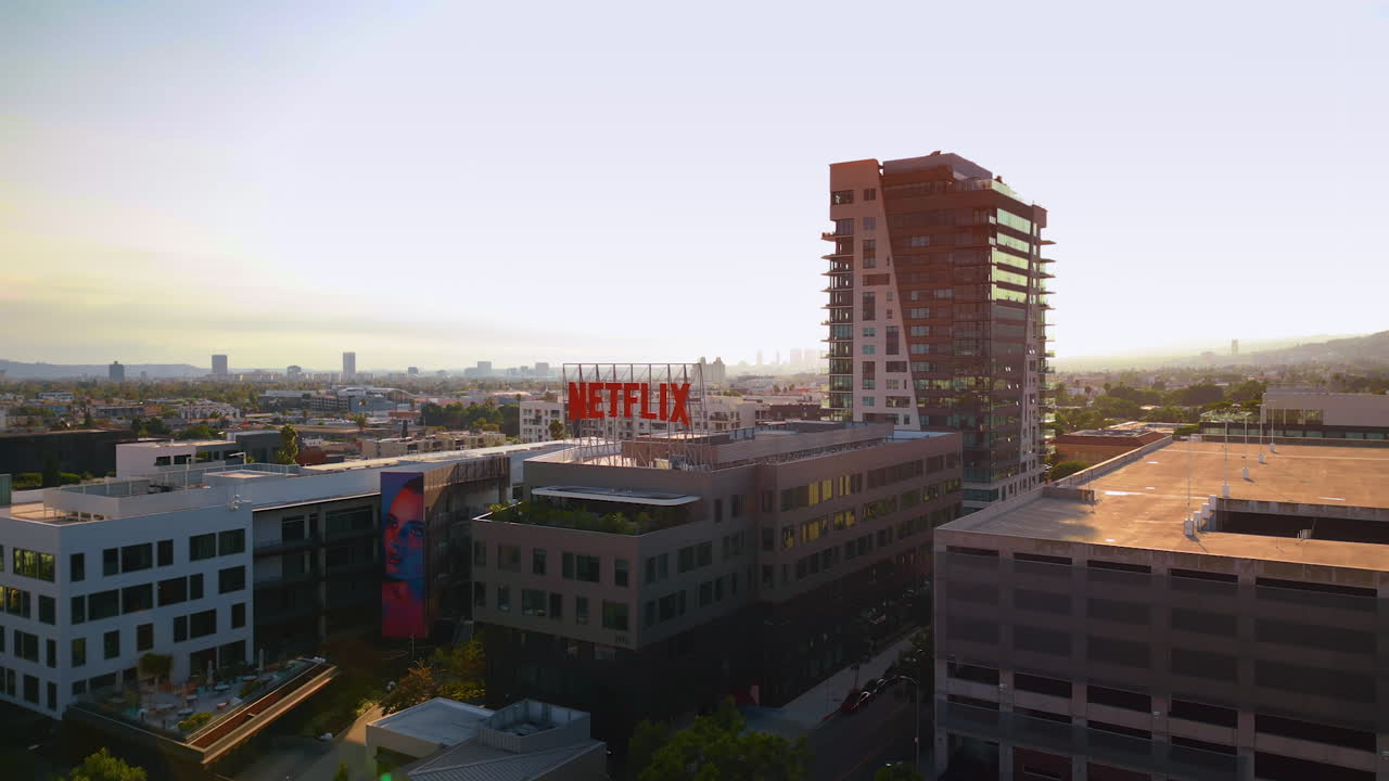 Los Angeles, USA, 29 August 2025: Red Netflix sign on top of the building. Company office in the scenery of LA, California, USA at sunset time. Aerial view