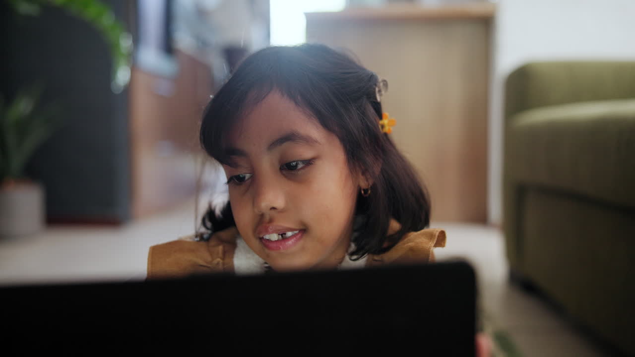 niña usando una tableta en casa