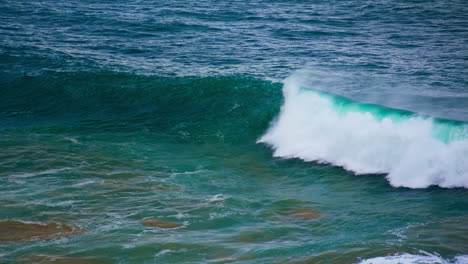 turquoise ocean wave swelling in slow motion. foamy powerful barrel rolling