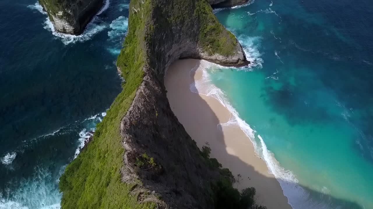 Velkolepý letecký záběr z dronu s pomalým náklonem vzhůru, zobrazující „ostrov dinosaurů“ – pláž Kelingking na Nusa Penida na Bali v Indonésii, připomínající Jurský park. Filmový pohled na útesy shora od Philippa Marnitze.