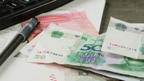chinese yuan bills, calculator, and documents